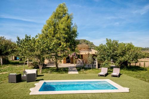 a swimming pool in a yard with chairs and a house at Es Camp Pla in Sineu