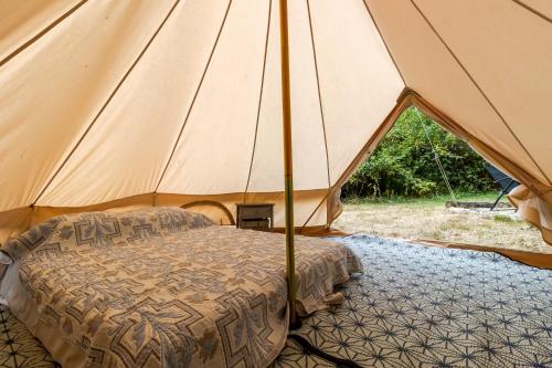 a tent with a bed in the middle at Tente Glamping Éco-Chic in Auriac-du-Périgord
