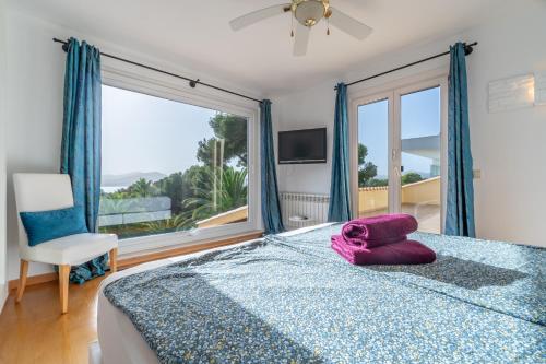 a bedroom with a bed and a large window at Finca Assindia, Costa de los Pinos in Son Servera