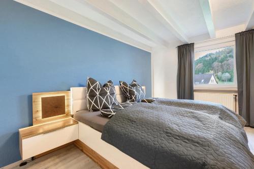 a bedroom with a bed with a blue wall at Grünes Tal - Seenah in Stockach