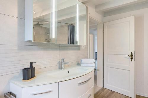 a white bathroom with a sink and a mirror at Grünes Tal - Seenah in Stockach
