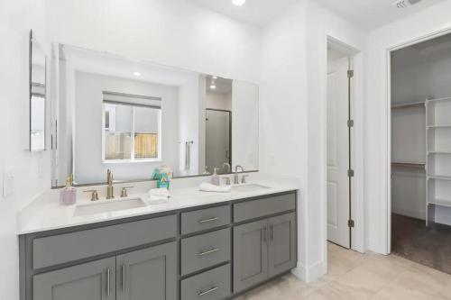 a bathroom with two sinks and a large mirror at Monthly or Daily Stay in Spacious 4BD for Family or Work with Outdoor backyard and BBQ grill in Folsom
