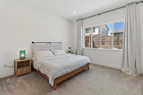 a bedroom with a bed and a large window at Monthly or Daily Stay in Spacious 4BD for Family or Work with Outdoor backyard and BBQ grill in Folsom