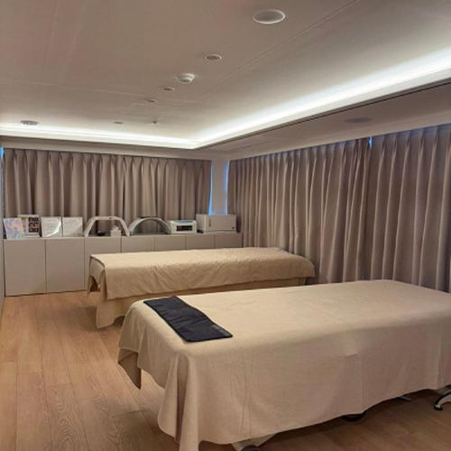 two beds in a hospital room with curtains at Ariana Hotel in Daegu
