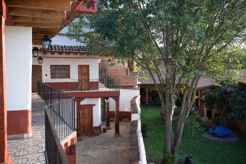 a house with a fence and a tree in the yard at La Casita de la Basílica in Pátzcuaro