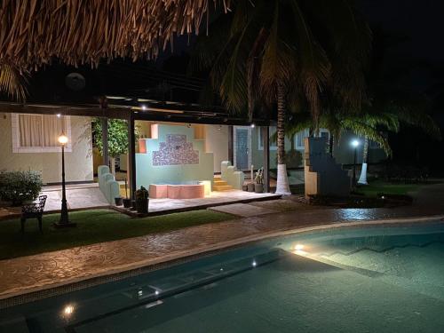 a swimming pool with a living room at night at Hotel Mecalco in Huazuntlán