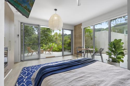 a bedroom with a large bed and a table and chairs at Secluded rainforest getaway in Currumbin Valley