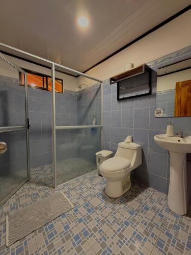 a bathroom with a toilet and a shower and a sink at Casa Osa Azul in Puerto Jiménez