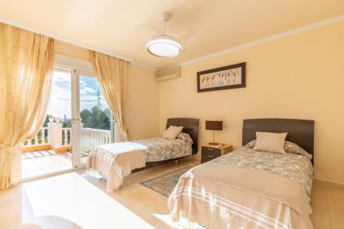 a bedroom with two beds and a balcony at Macondo Altea Hills in Altea