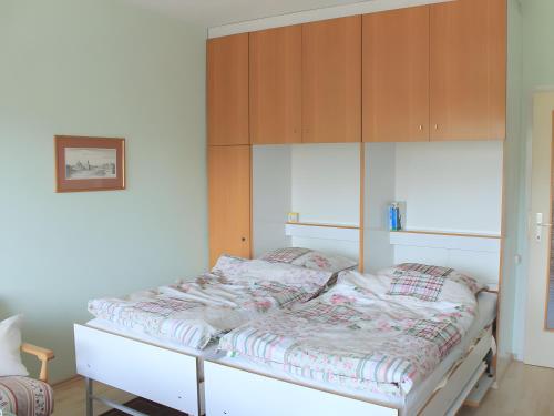 a bed in a room with wooden cabinets at Sonnenalm - Ferienwohnung in Reith