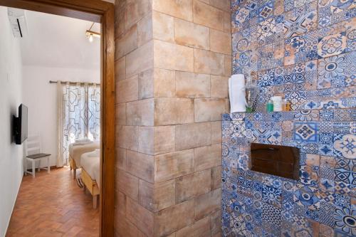 a room with a tile wall with a fireplace at Casas do Monte I - T2 in Mértola
