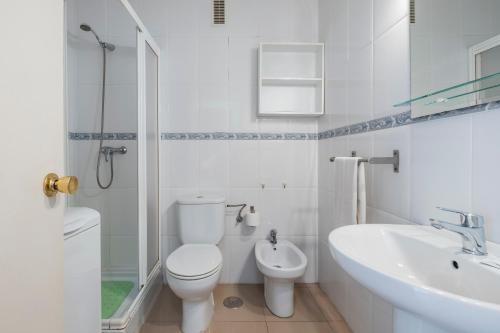 a white bathroom with a toilet and a sink at Estudio Bloque 89 in Torrox