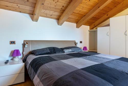 a bedroom with a large bed and wooden ceilings at Appartamento Cles in Cles