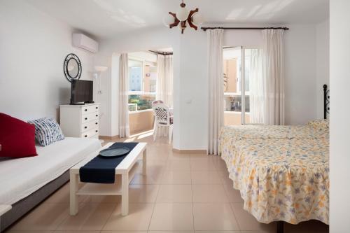 a white bedroom with a bed and a couch at Estudio Bloque 89 in Torrox