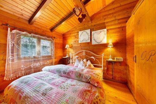 a bedroom with a bed in a wooden cabin at Orserose Chalet 6 I Scarpet in Forno di Zoldo