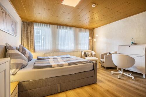 a bedroom with a bed and a desk and a chair at Ferienhaus Bergmannsruh in Clausthal-Zellerfeld