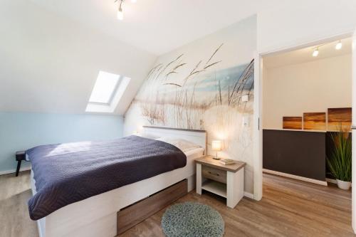 a bedroom with a bed and a painting on the wall at Feriendoppelhaus Sommer in Stakendorf