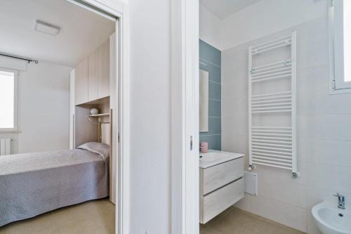 a white bathroom with a bed and a sink at Casa d'a mare in Torre San Giovanni Ugento