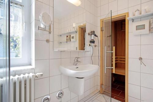 a white bathroom with a sink and a mirror at Haus Schilfblick in Wieck