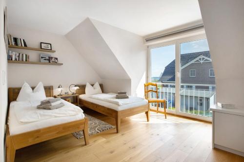 a bedroom with two beds and a large window at Haus Schilfblick in Wieck