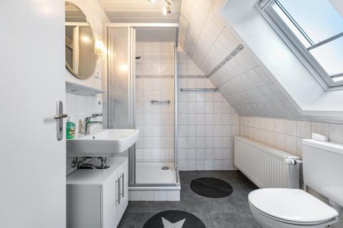 a bathroom with a sink toilet and a shower at Ferienhaus Magda in Stadum
