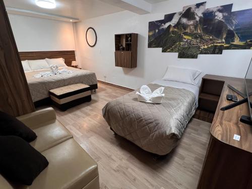 a hotel room with two beds and a couch at Inca Wasi Plaza de Armas in Cusco