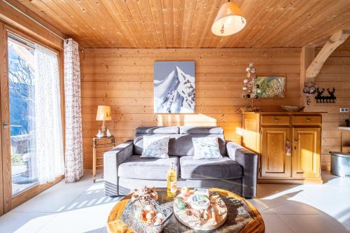 a living room with a couch and a table at Tié No Appartement Chaleureux in Manigod