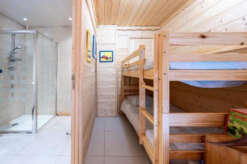 a bathroom with two bunk beds and a shower at Tié No Appartement Chaleureux in Manigod