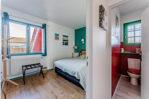 a bedroom with a bed and a sink and a toilet at Chambre D'hote Chez Amaya in Gujan-Mestras