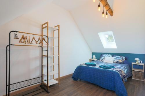 a bedroom with a bed with a blue comforter at Maison de vacances Kerkohann in Tressignaux