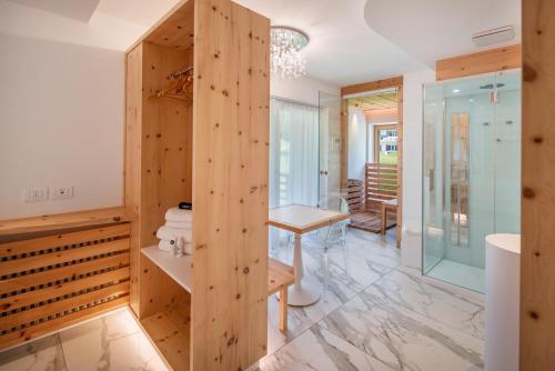 a bathroom with a wooden wall and a table at Apart Wellness Alpino con minispa in Soraga