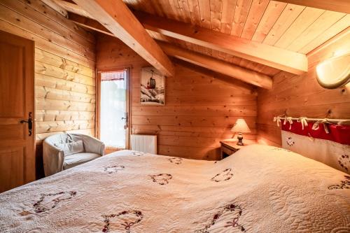 a bedroom with a large bed in a wooden room at Chalet Marmottes in Morillon