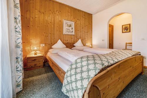 a bedroom with two beds and a wooden wall at Apartment Sonnenschein in Mühlbach