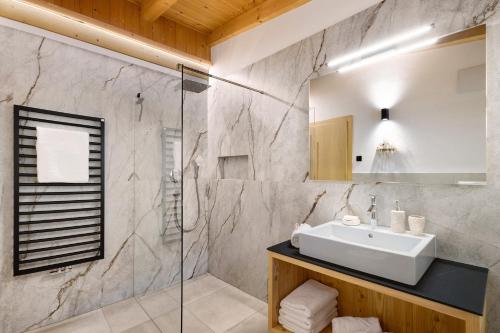 ein Badezimmer mit Waschbecken und Dusche in der Unterkunft Maierhof in Wengen