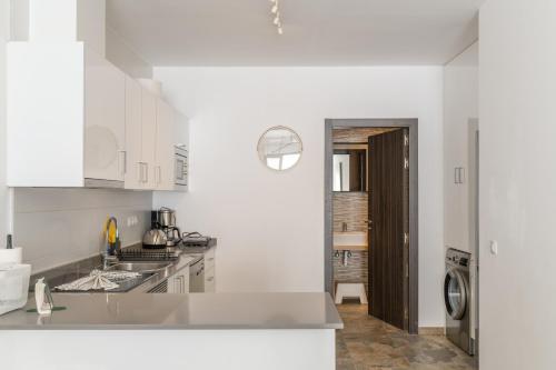 a white kitchen with a sink and a dishwasher at Casa Bidasoa 35 in Playa Blanca