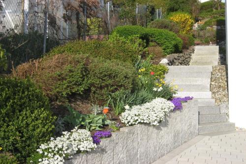 a garden with a bunch of flowers and stairs at Ferienwohnung Nell in Daisendorf