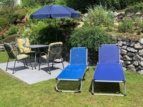 four chairs and a table with an umbrella at Ferienwohnung Nell in Daisendorf