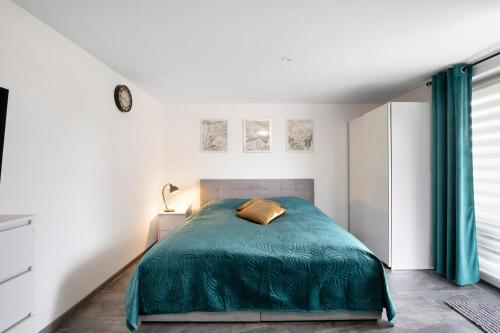 a bedroom with a bed with a green blanket at Ferienwohnung am Wartberg in Herbrechtingen