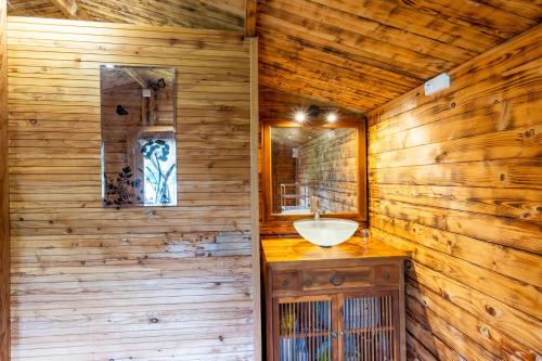 a bathroom with a sink in a wooden wall at Cabane aux étoiles in Auriac-du-Périgord