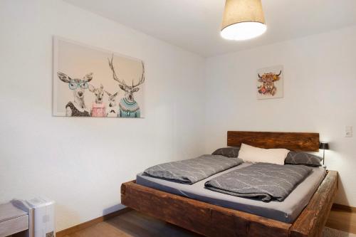 a bedroom with a bed with a picture of deer on the wall at Ruhige Schwarzwald Ferienwohnung in Buchenbach