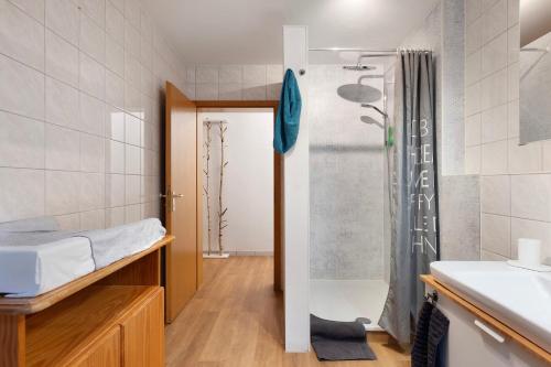 a small bathroom with a shower and a bed at Ruhige Schwarzwald Ferienwohnung in Buchenbach