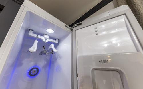 a small white refrigerator with utensils in it at Iksan Hotel G7 in Songman