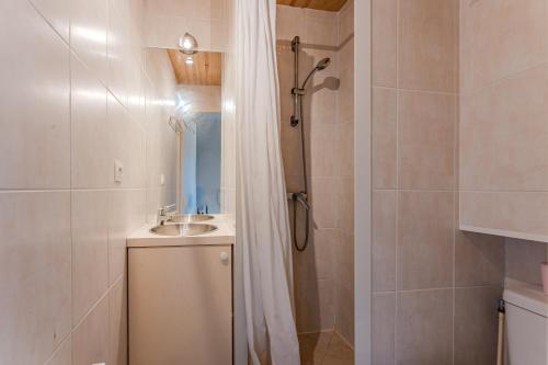 a bathroom with a shower with a sink and a shower curtain at La Forestière Cap Ferret - Réf 2 in Lège-Cap-Ferret