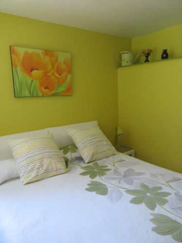 a bedroom with a bed with two pillows on it at Chambres Paysannes Lecarpentier - in Fontenay