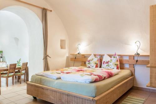 a bedroom with a bed in a room with a table at Moserhof Ferienwohnung Sunnseit in Sarntal