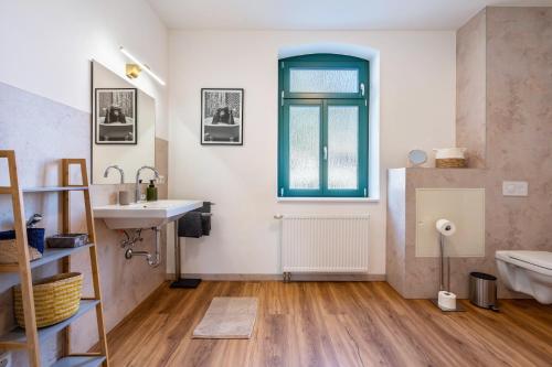 a bathroom with a sink and a tub and a window at Villa Rathmannsdorf in Rathmannsdorf