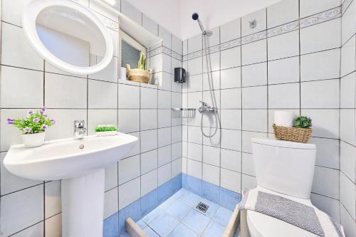 a white bathroom with a sink and a toilet at Dolphin studio in Gaios