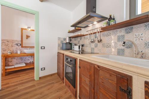 a kitchen with a sink and a stove at Trulli House in Putignano