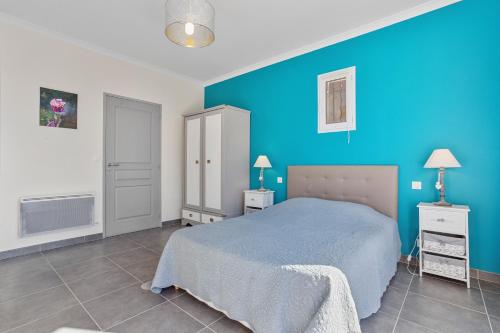 a blue bedroom with a bed and a blue wall at La Vue des Anges in Draguignan
