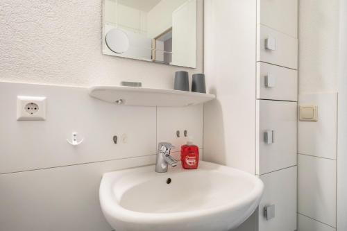a white bathroom with a sink and a mirror at Obsthof Mainberger in Kressbronn am Bodensee
